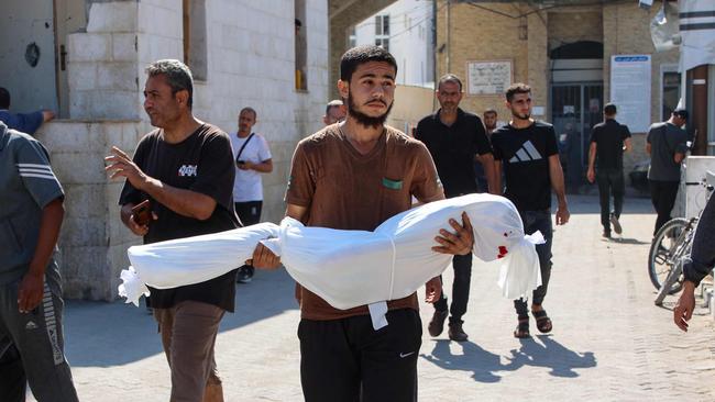 A relative carries the shrouded body of 10-year-old Sama al-Debs, who was killed during an Israeli army operation in the Jabalia refugee camp in the central Gaza Strip, ahead of her funeral on October 18. Picture: Omar Al-Qattaa / AFP