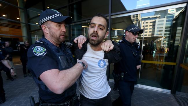 A protester is arrested by police after he tried to gain access to the South Australian Liberal party Annual General Meeting at the Adelaide Convention Centre. Picture: Kelly Barnes/AAP