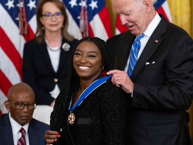 Biden puts the medal on Biles. Picture: Saul Loeb/AFP