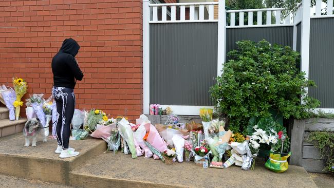 A well-wisher lays flowers at a memorial outside the Glen Waverley home.