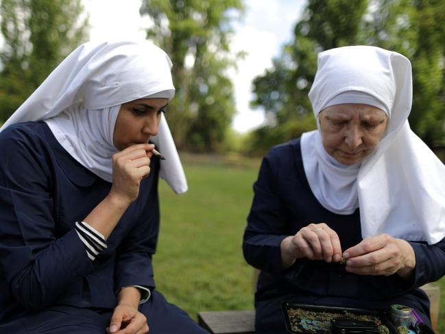 California "weed nun" Christine Meeusen, 57, (R), and India Delgado, who goes by the name Sister Eevee, smoke a joint at Sisters of the Valley near Merced, California, U.S., April 18, 2017. Picture taken April 18, 2017. REUTERS/Lucy Nicholson