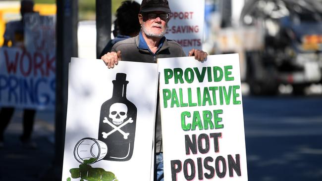 Protesters hold signs outside Parliament House. Picture: NCA NewsWire / Dan Peled