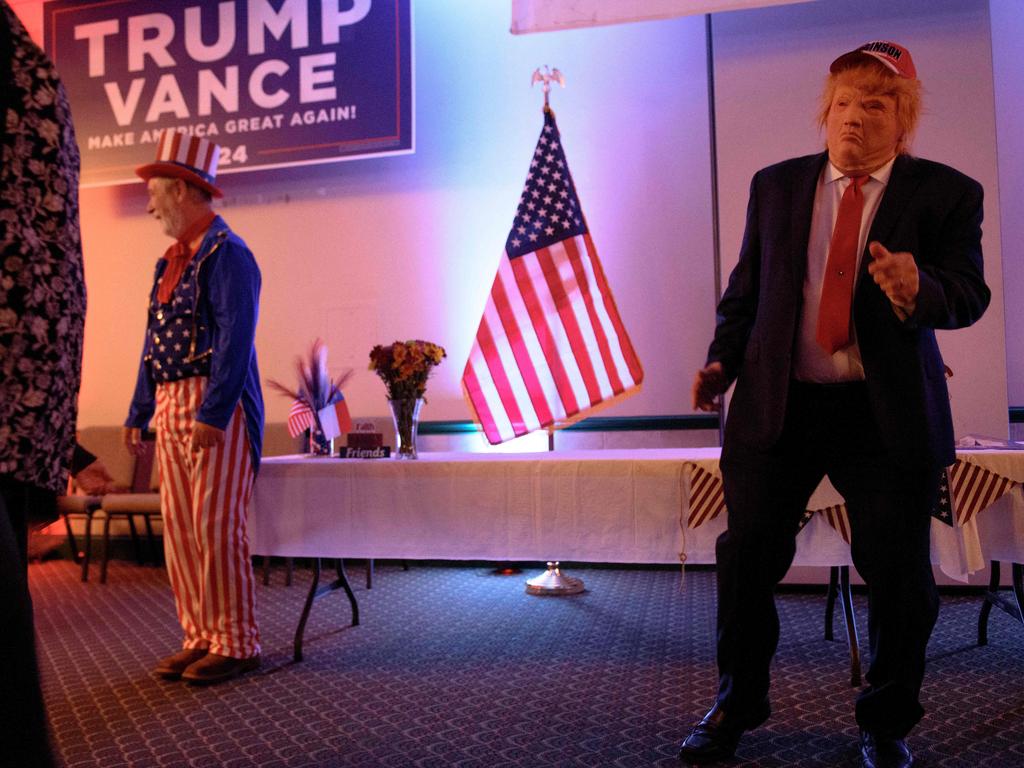 A man in a Trump mask dances with members of the Catawba County Republicans at a watch party in Newton, North Carolina. Picture: Getty Images.