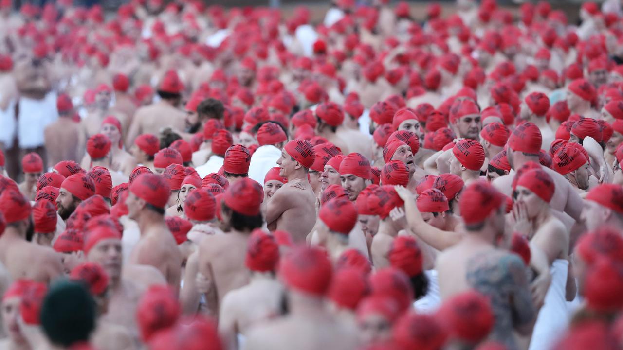 DARK MOFO 2019: Participants of the nude solstice swim brave the cold water at dawn at Long Beach, Sandy Bay. Picture: LUKE BOWDEN