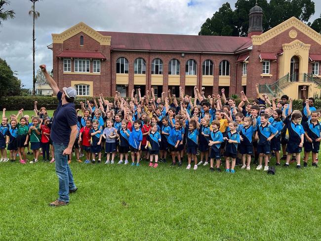 Australian country music star Josh Arnold and Tully State School students teamed up to create new song, 'Tumblin' Tully Rain' to celebrate the town's centenary. Photo: Facebook.