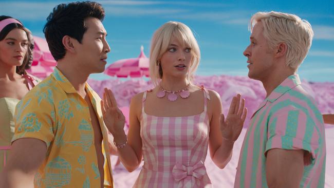 Margot Robbie as Barbie with Simu Liu and Ryan Gosling as rival Kens in a scene from Barbie.