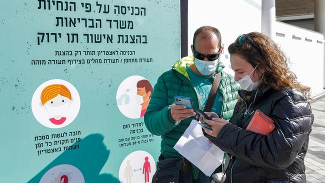 Attendees prepare to present their "green passes" (proof of being fully vaccinated against COVID-19 coronavirus disease) as they arrive at Bloomfield Stadium in the Israeli Mediterranean coastal city of Tel Aviv on March 5, 2021, before attending a "green pass concert". Picture: Jack Guez/AFP