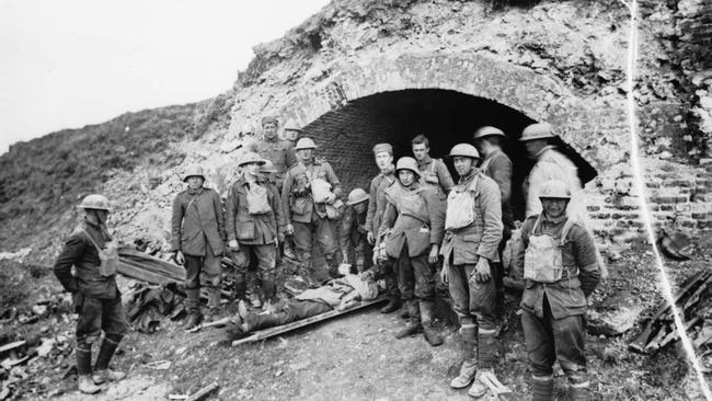 German prisoners resting with a wounded comrade at one of the access entrances to the St Quentin Canal tunnel, in the captured Hindenburg Defence System. Picture: Courtesy Australian War Memorial