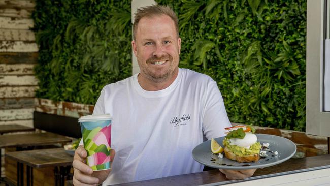 Scott Imlach holding a smashed avo dish at The Backyard Cafe. Picture: Jerad Williams