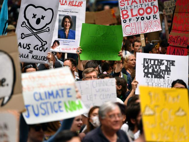 Demonstrators hold up placards at a climate protest rally in Sydney on December 11, 2019. - Up to 20,000 protesters rallied in Sydney on December 11 demanding urgent climate action from Australia's government, as bushfire smoke choking the city caused health problems to spike. (Photo by Saeed KHAN / AFP)