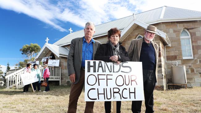 Protesters at St Martin’s Church in Dunalley (L-R) Andrew Dunbabin, Lyn Steele and George Whitehouse, protesting that the Anglican Church has deconsecrated the church with little warning. Picture: LUKE BOWDEN