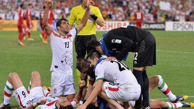 Reza Ghoochannejhad of Iran is congratulated by teammates after scoring the winner.