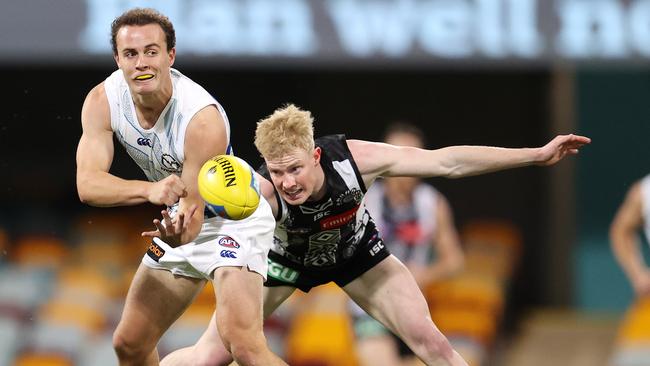 Roo Jack Mahony dishes off a handball in front of Magpie John Noble. Picture: Michael Klein