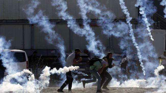 Palestinian youths engulfed by teargas fired by Israeli security forces in Ramallah. Picture: AFP