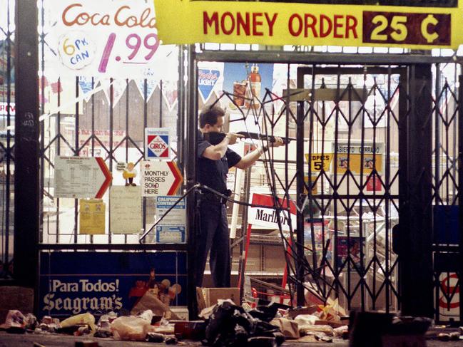 A Los Angeles police officer takes aim at a looter in a market at Alvarado and Beverly Boulevard in Los Angeles. Picture: AP