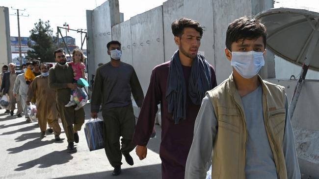 Afghans, hoping to leave Afghanistan, walk to the main entrance gate of Kabul airport in Kabul. Picture: AFP