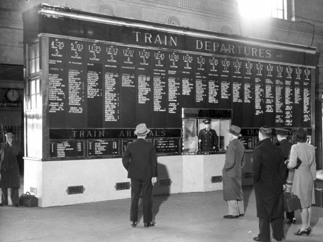 Passengers check the departures and arrivals board at Adelaide Railway Station. Date unknown.