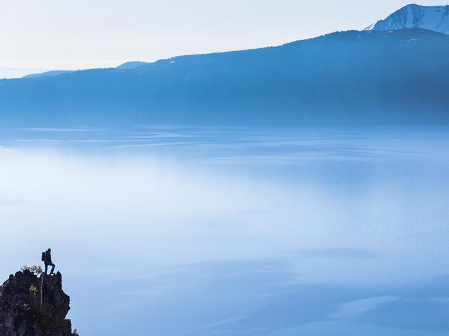 hiker looks at the view of the Crater Lake, Oregon. Oregon native