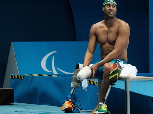 South Africa's Achmat Hassiem puts on his prosthesis after competing a heat of men's 100 m freestyle (S10) of the Rio 2016 Paralympic Games at Olympic Park in Rio de Janeiro on September 13, 2016. / AFP PHOTO / YASUYOSHI CHIBA