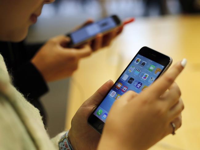 Customers try out a new Apple iPhone 6S at an Apple store on Chicago's Magnificent Mile, Friday, Sept. 25, 2015, in Chicago. (AP Photo/Kiichiro Sato)