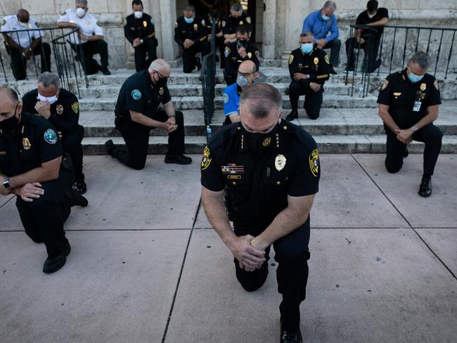 Police officers kneel during a rally in Coral Gables, Florida in response to the recent death of George Floyd, an unarmed black man who died while being arrested and pinned to the ground by a white Minneapolis police officer. Picture: AFP