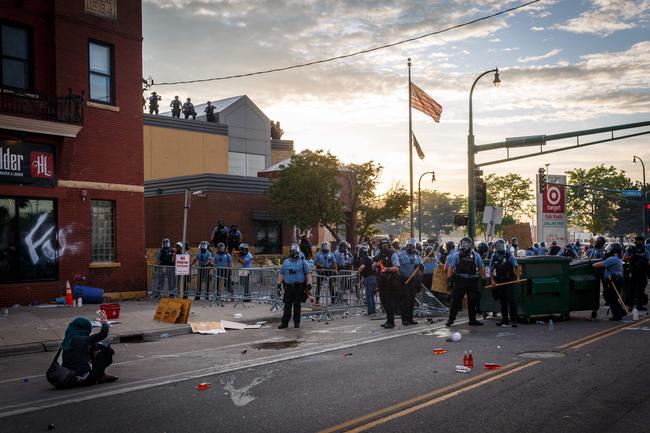 A protester sits on the ground and gestures to police during a demonstration in Minneapolis. Picture: AFP