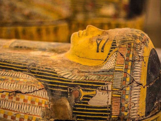 A photograph taken on October 19, 2019 shows a detail of a sarchphagus displayed in front of Hatshepsut Temple in Egypt's valley of the Kings in Luxor - Egypt revealed today a rare trove of 30 ancient wooden coffins that have been well-preserved over millennia in the archaeologically rich Valley of the Kings in Luxor. The antiquities ministry officially unveiled the discovery made at Asasif, a necropolis on the west bank of the Nile River, at a press conference against the backdrop of the Hatshepsut Temple. (Photo by Khaled DESOUKI / AFP)