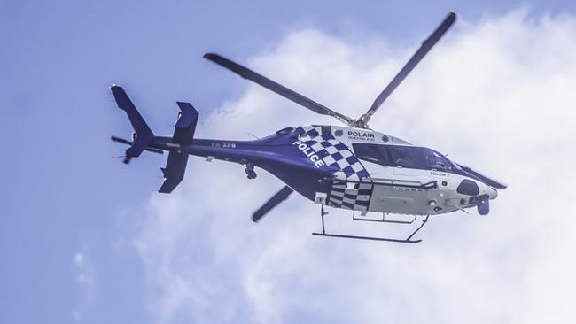 The PolAir 2 helicopter flies laps over Gilston in search of three alleged armed robbers on the loose. Photo: Luke Sorensen