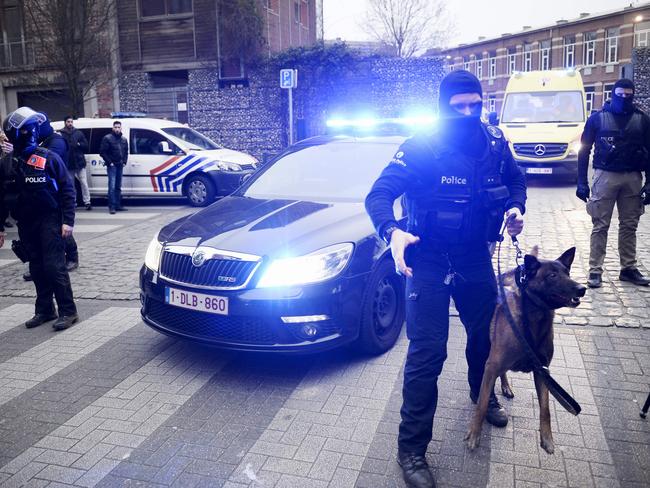 Policemen block a road, near the scene of a police raid in the Molenbeek-Saint-Jean district in Brussels, on March 18, 2016, as part of the investigation into the Paris November attacks. The main suspect in the jihadist attacks on Paris in November, Salah Abdeslam, was arrested in a raid in Brussels on March 18, French police sources said. / AFP PHOTO / BELGA / DIRK WAEM / Belgium OUT