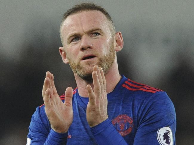 Manchester United's Wayne Rooney waves a match.