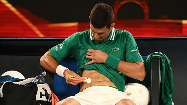 Novak Djokovic treats his side strain during the match. Picture: Getty Images