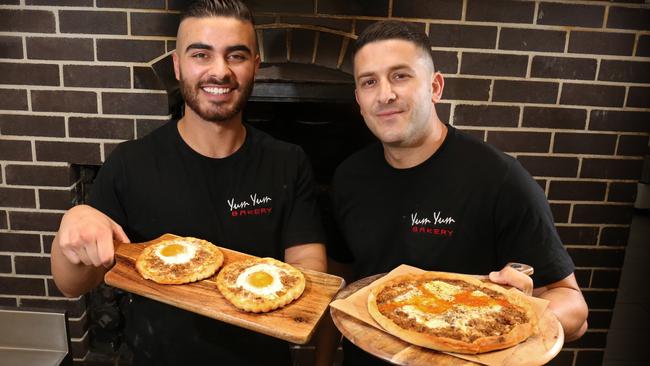 Yum Yum Bakery’s Jeremy Agha and Najib Haddad with their awarma and egg pizza. Picture: Robert Pozo