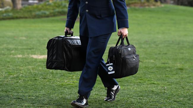 A military aide carries the president’s nuclear ‘football’ in his right hand as US President Donald Trump returns to the White House during his presidency. Picture: Olivier Douliery/AFP