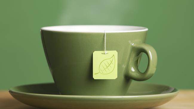 A cup of steaming hot tea in a green cup