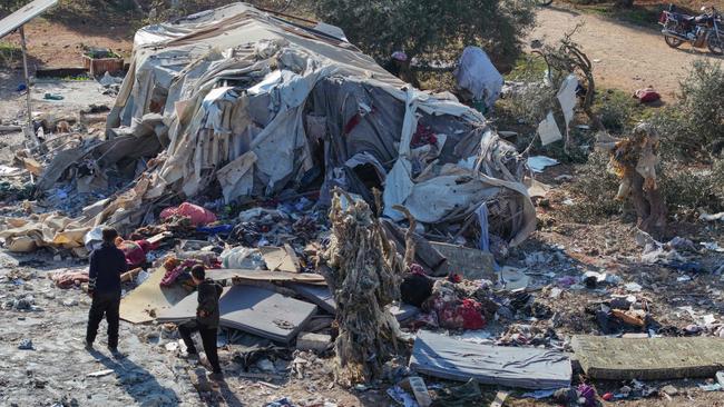 An aerial picture shows people inspecting damage after an airstrike on makeshift camp for displaced Syrians near the town of Maarrat Misrin in the northern part of Idlib.