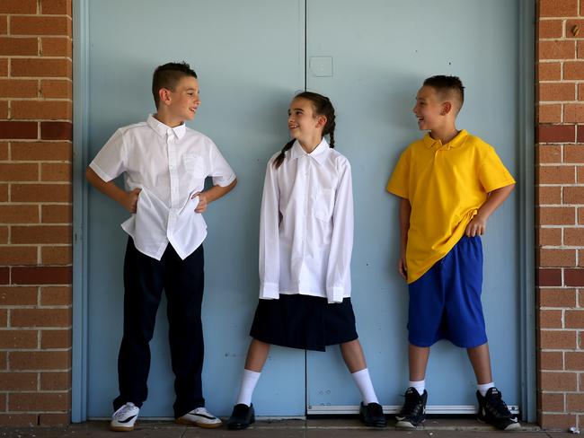 Triplets Cooper, Olivia and Isaac Giuliano from Sydney pictured in uniforms available to their age group. Picture: Toby Zerna