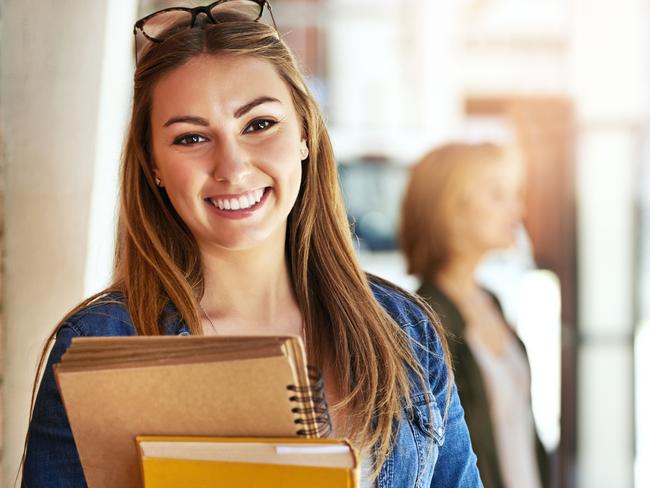 CAREERS FOR MARCH 30 EXPO COVER: Portrait of a smiling female university student standing on campus with friends in the background