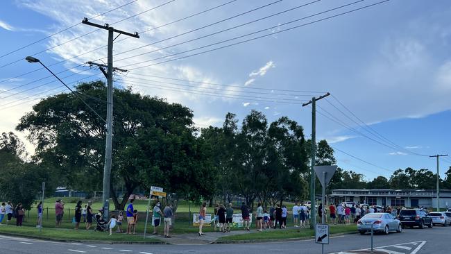 Residents queue up for food and other essentials at the air drop on Wednesday afternoon.