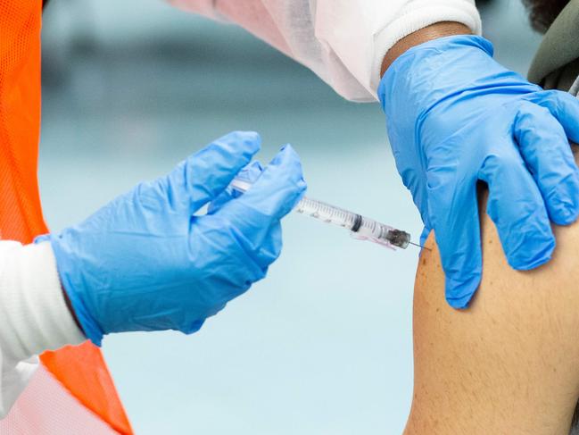 (FILES) In this file photo a man receives a dose of the Moderna coronavirus disease (COVID-19) vaccine at a vaccination site at South Bronx Educational Campus, in the Bronx New York on January 10, 2021. - US biotechnology firm Moderna on January 25, 2021 said lab studies showed its Covid-19 vaccine would remain protective against variants of the coronavirus first identified in the United Kingdom and South Africa. "The study showed no significant impact" on the level of neutralizing antibodies elicited against the UK variant, B.1.1.7. (Photo by Kena Betancur / AFP)