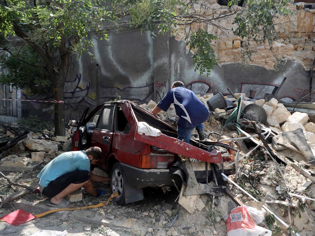 Local residents pull a car out from under the rubble in Odessa the day after a military strike, amid the Russian invasion of Ukraine. Picture: AFP