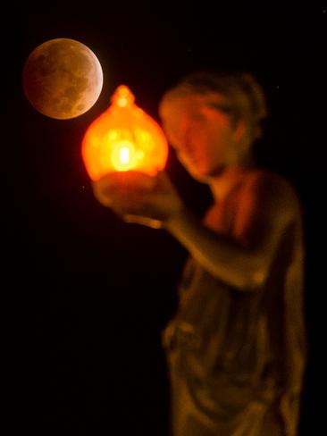 A lunar eclipse dips down behind the Wheeler Town Clock in Manitou Springs, Colorado. Picture: AP