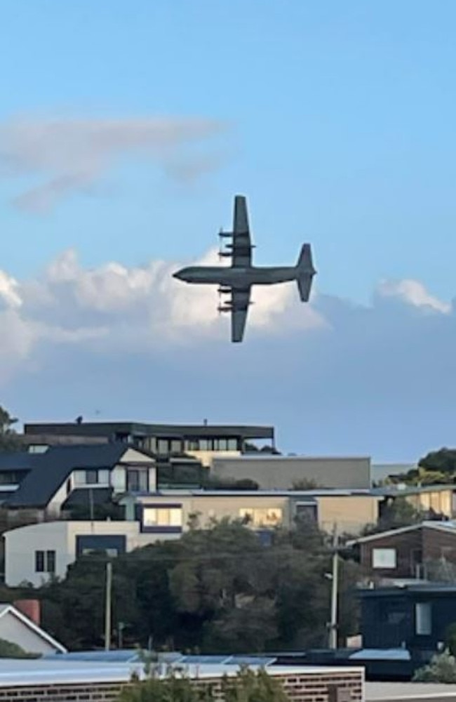 A RAAF plane flying low over houses and the coastline at Ocean Grove.
