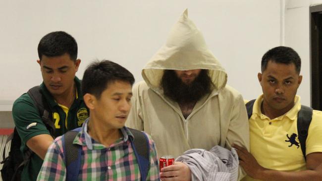 Philippine police operatives escort hooded Australian Islamic preacher Robert Cerantonio in 2014. Picture: AP Photo