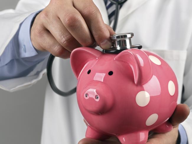 Doctor holding stethoscope to piggy bank