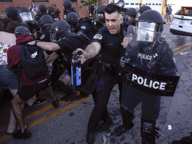 A police officer deploys a can of pepper spray at protesters in Des Moines, Iowa. Picture: Bryon Houlgrave/The Des Moines Register via AP