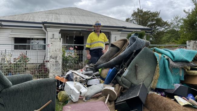 Graham Wilson standing among the rubbish outside his parents house in Molong.