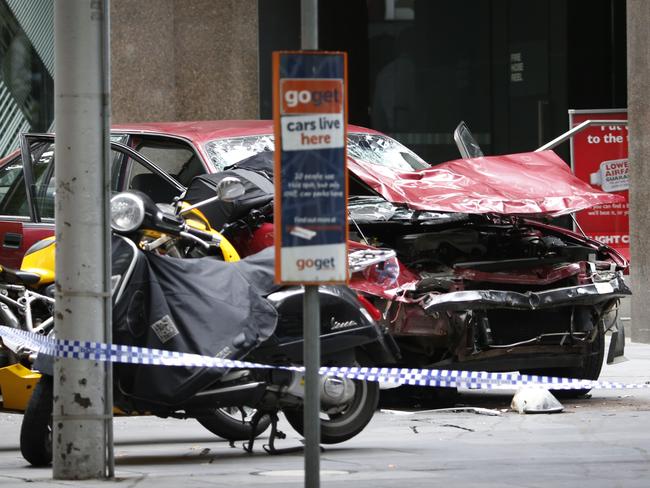 The mangled red Holden with the bucket section of the dead baby’s pram wedged into its bonnet after it came to rest in Bourke Street. Picture: David Caird