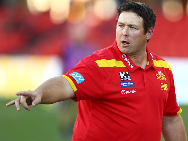 GOLD COAST, AUSTRALIA - JUNE 19: Suns coach Stuart Dew talks to players during the round 14 AFL match between the Gold Coast Suns and the Port Adelaide Power at Metricon Stadium on June 19, 2021 in Gold Coast, Australia. (Photo by Chris Hyde/Getty Images)