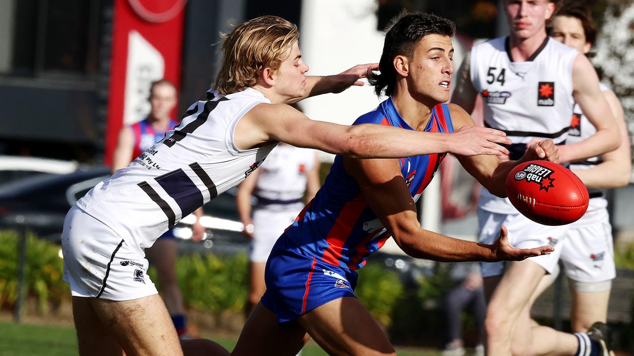 Daicos gets his handball away in front of Jackson Archer. Picture: Michael Klein