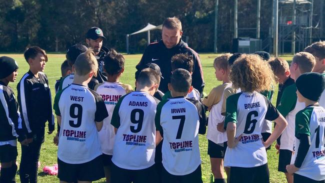 Caravella Football Academy players get some advice from Western Sydney Wanderers youth coach Arthur Diles.